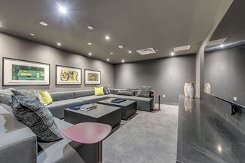A modern living room with grey couches and a pink table.